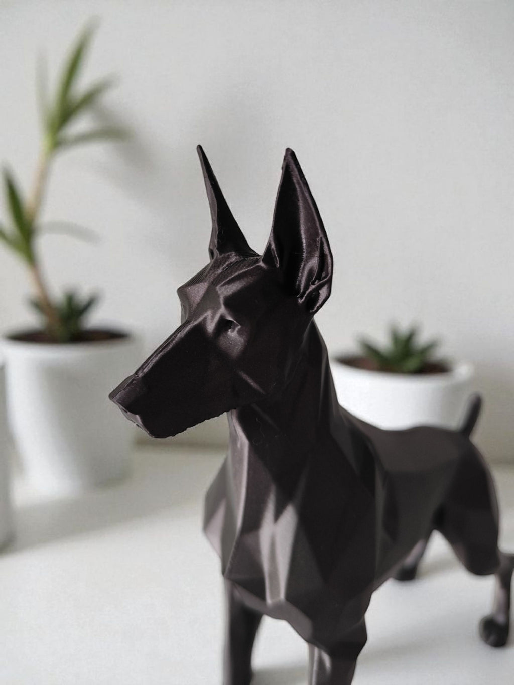 Geometrisk dobermann figur i mat sort nærbillede