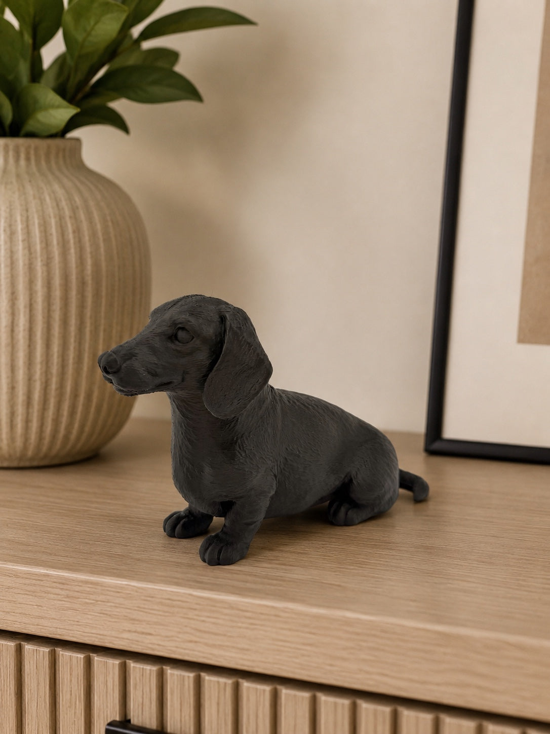 Sort gravhund figur set fra siden