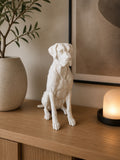 Hvid siddende labrador hundefigur i boligindretning
